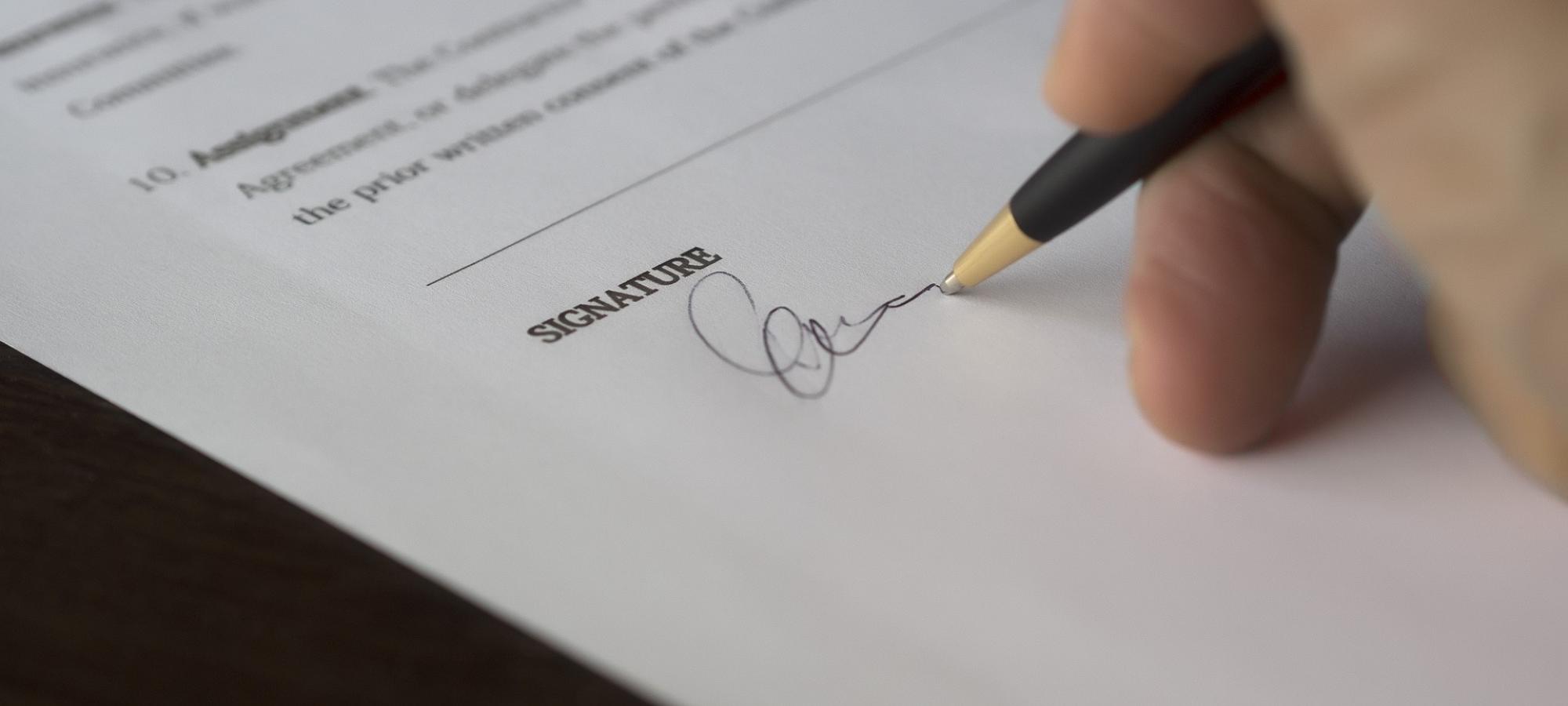 stock image of a person signing their name