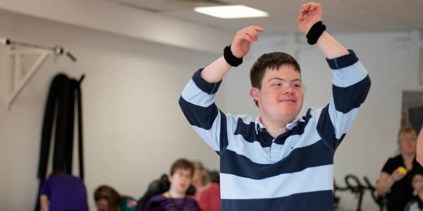 Young adult with his arms in the air dancing