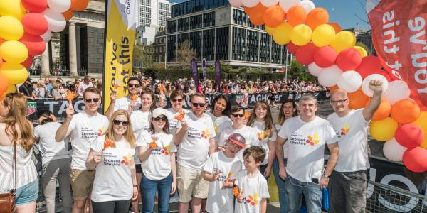 A group on people in Leonard Cheshire branded tshirts at a cheer point at the London Marathon