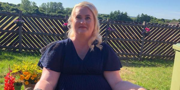 Kerry Thompson in a formal black dress in a garden