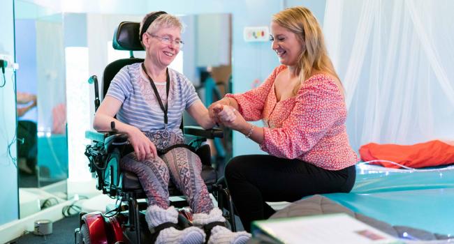 A carer supports one of our residents with muscle movement in her wrist