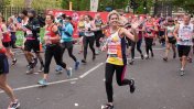 London marathon runner Katy in a Leonard Cheshire vest waving at supporters 
