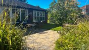 Exterior view of paved garden patio and green shrubs 