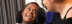 A dark skinned female resident smiling at a Caucasian female care worker