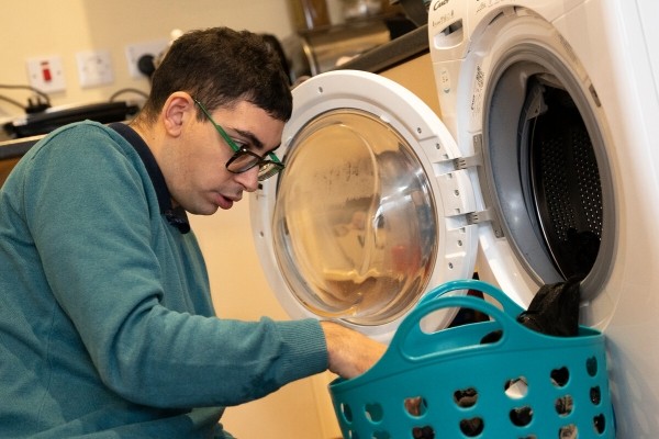 Jonathan using a washing machine at Eden Square