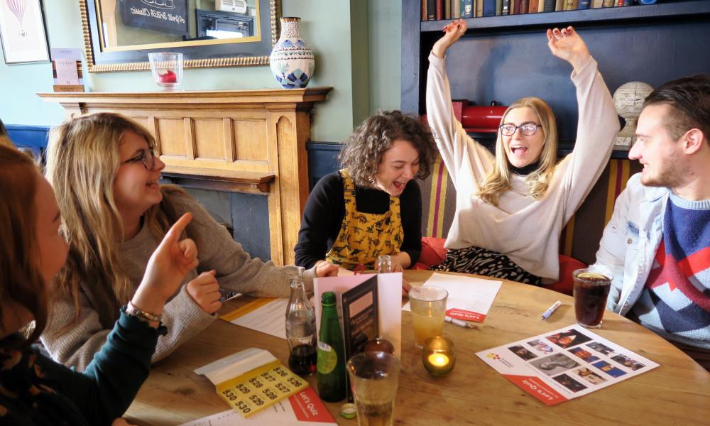 Quiz team sitting around a table cheering