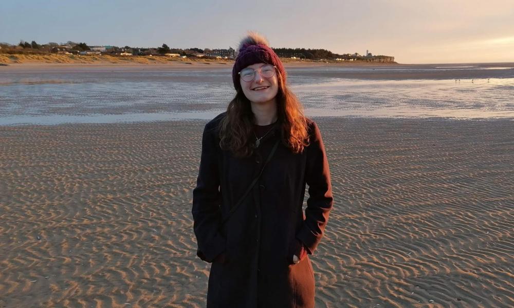 Ray standing on a beach smiling