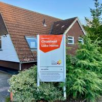 Front entrance of Leonard Cheshire Care Home in Chipstead with a white and orange branded sign in front of the home 