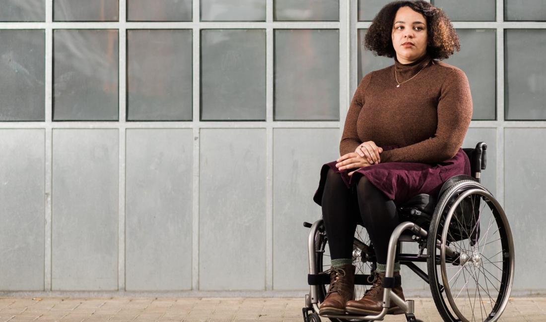 Cassie in her wheelchair in front on a glass building